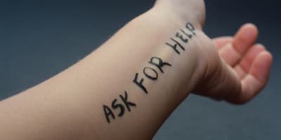 ask for help written on wrist